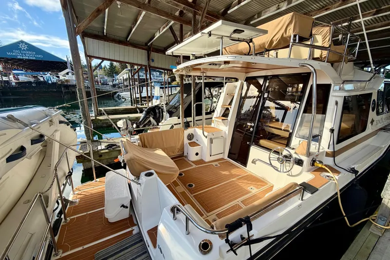 Slide: The Image of 2018 Ranger Tugs R-29 CB docked at marina, showcasing spacious deck and modern design. - 10