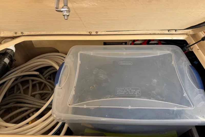 Slide: The Image of Storage compartment in 2018 Ranger Tugs R-29 CB with plastic container and coiled hoses. - 16