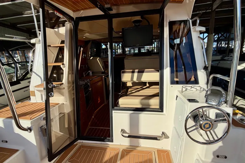 Slide: The Image of 2018 Ranger Tugs R-29 CB interior with helm, seating, and wooden flooring. - 25