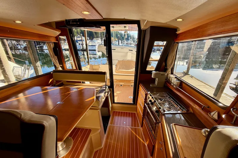 Slide: The Image of Interior of 2018 Ranger Tugs R-29 CB, featuring wood finishes and marina view. - 31