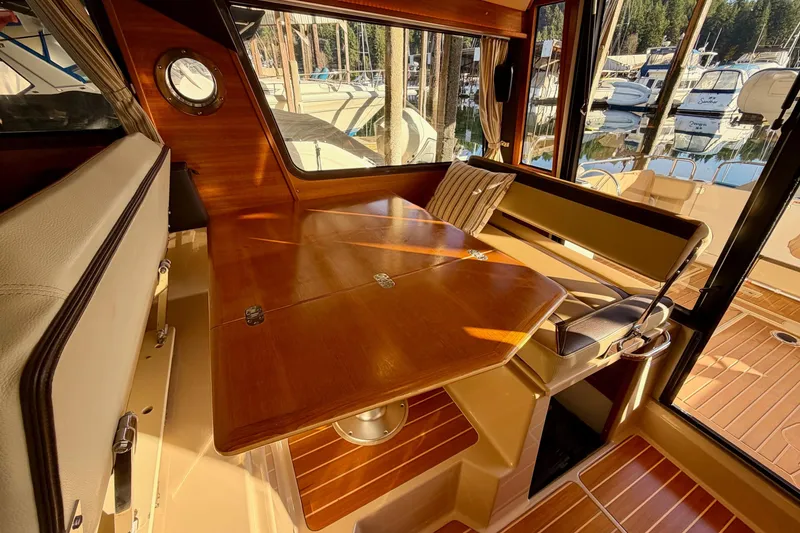 Slide: The Image of Interior of 2018 Ranger Tugs R-29 CB with wooden table and seating, docked at marina. - 35
