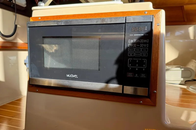 Slide: The Image of Microwave oven inside 2018 Ranger Tugs R-29 CB boat, featuring wood trim and digital controls. - 49