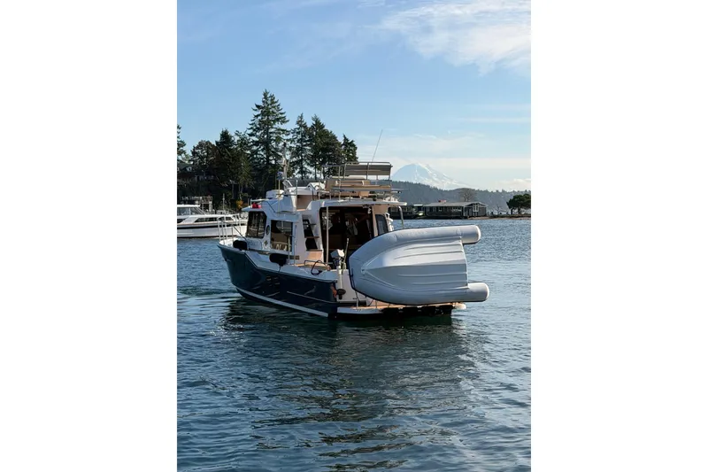 Slide: The Image of 2018 Ranger Tugs R-29 CB boat on serene water with scenic background. - 5