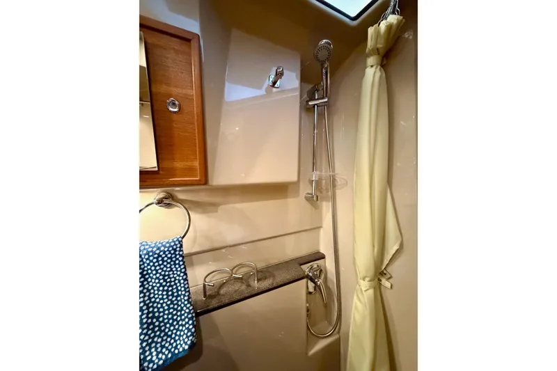 Slide: The Image of 2018 Ranger Tugs R-29 CB bathroom with shower, curtain, and towel rack. - 56