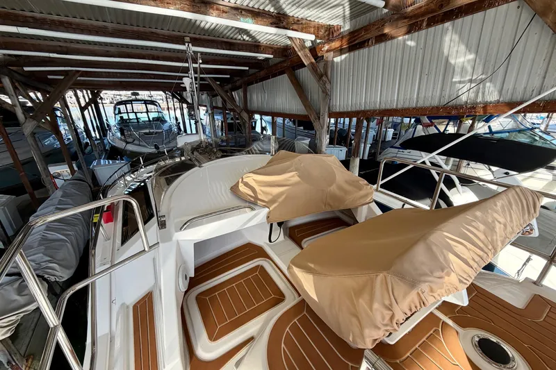 Slide: The Image of 2018 Ranger Tugs R-29 CB boat docked in a covered marina, featuring tan seat covers. - 58