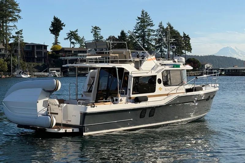Slide: The Image of 2018 Ranger Tugs R-29 CB cruising on a scenic waterway with trees and mountains. - 6