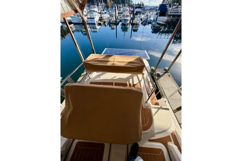 Slide: The Image of 2018 Ranger Tugs R-29 CB at marina, featuring solar panel and covered seating. - 60