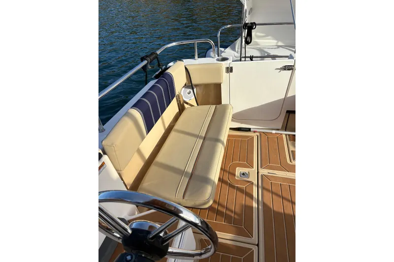 Slide: The Image of 2018 Ranger Tugs R-29 CB boat interior with tan seating and wooden deck. - 69