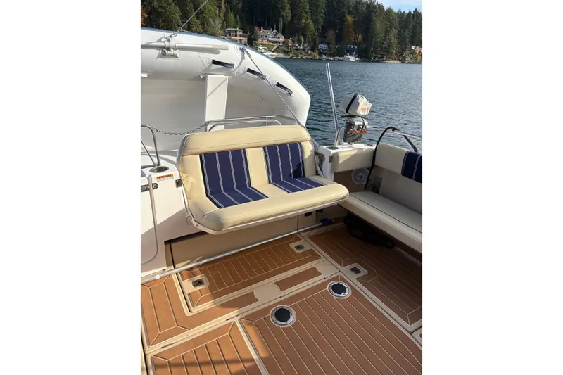 Slide: The Image of 2018 Ranger Tugs R-29 CB boat interior with striped seating and wooden deck. - 70