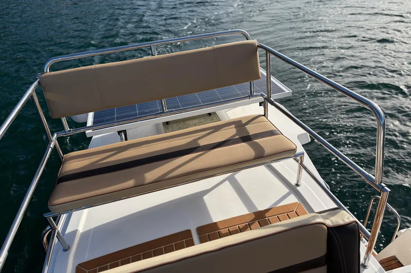 Slide: The Image of 2018 Ranger Tugs R-29 CB boat deck with cushioned seating and railing on water. - 72