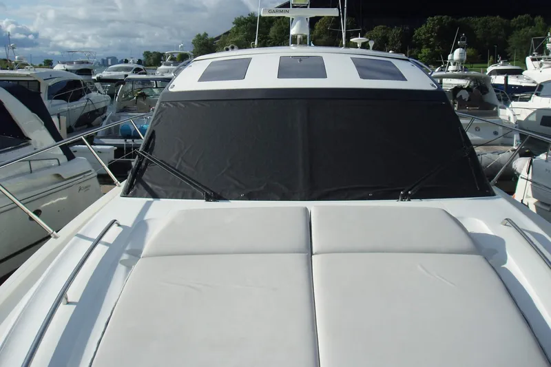 Slide: The Image of 2015 Princess V48 yacht docked at marina, featuring sleek design and sunbed. - 12