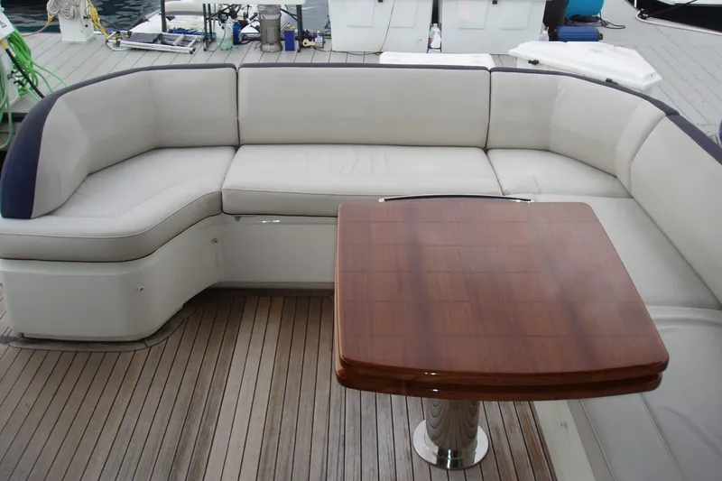 Slide: The Image of Luxurious seating area on 2015 Princess V48 yacht with wooden table and cushioned bench. - 14