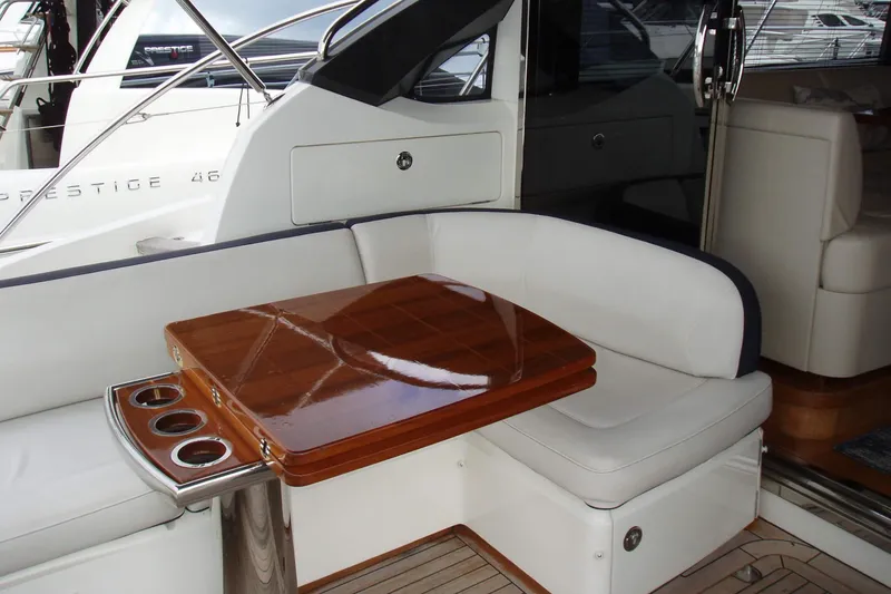 Slide: The Image of Luxurious seating area on a 2015 Princess V48 yacht with wooden table and cup holders. - 15