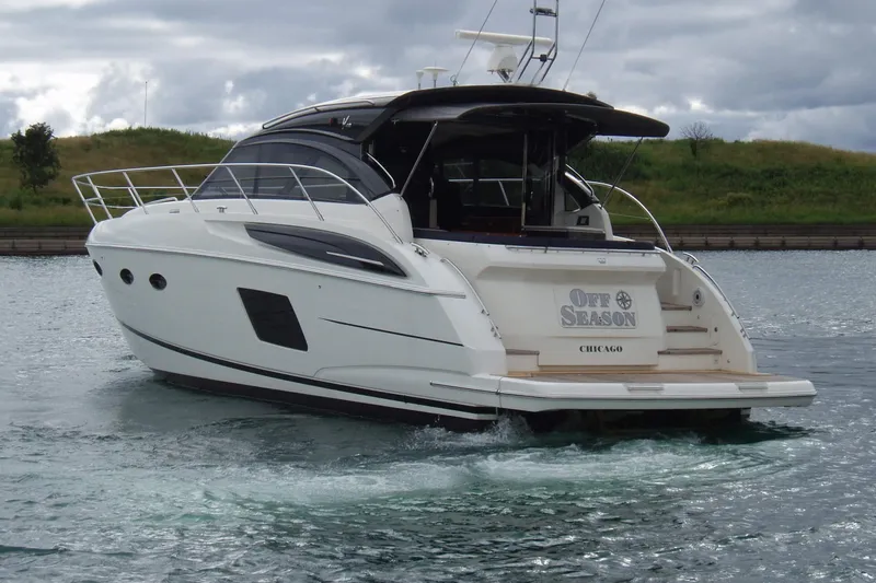 Slide: The Image of 2015 Princess V48 yacht cruising on a calm waterway under cloudy skies. - 4