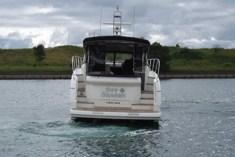 Slide: The Image of 2015 Princess V48 yacht named "Off Season" on a calm waterway. - 5