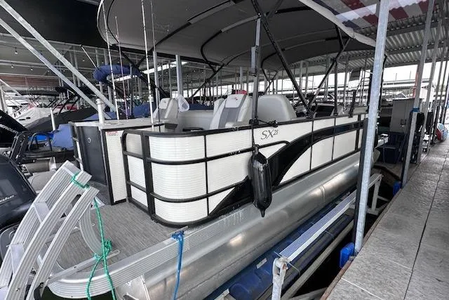 Slide: The Image of 2023 Bennington SX 21 Fishing boat docked in a marina, side view. - 2
