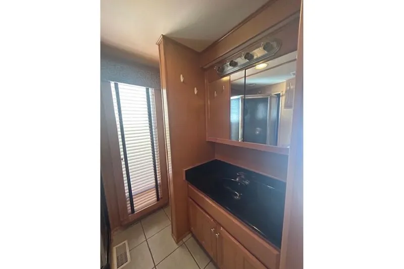 Slide: The Image of 2007 Sumerset Lakeview HD bathroom with wooden cabinets and black countertop. - 25