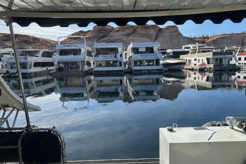 Slide: The Image of 2007 Sumerset Lakeview HD houseboats docked on calm water with rocky backdrop. - 29