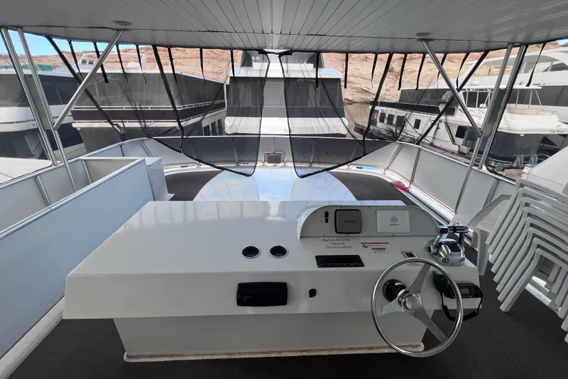 Slide: The Image of 2007 Sumerset Lakeview HD houseboat helm with steering wheel and controls, docked among other boats. - 36