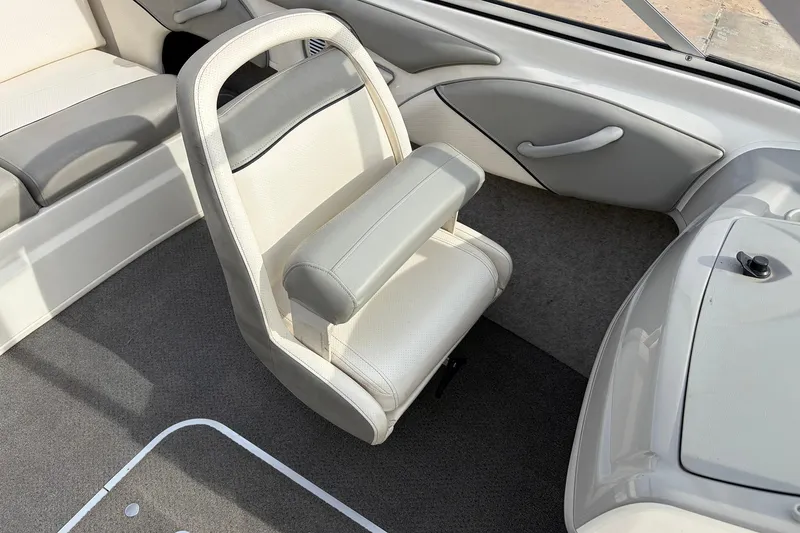 Slide: The Image of Interior of a 2011 Bayliner 185 boat featuring a white and gray captain's chair. - 20
