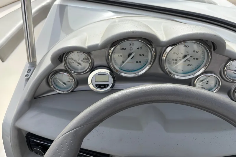 Slide: The Image of Dashboard of a 2011 Bayliner 185 boat with gauges and steering wheel. - 24
