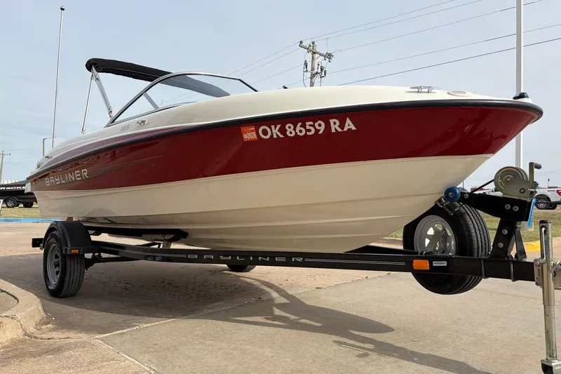 Slide: The Image of 2011 Bayliner 185 boat on trailer, red and white design, parked outdoors. - 3