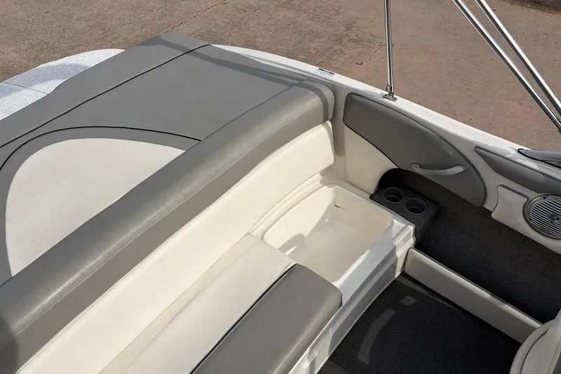 Slide: The Image of 2011 Bayliner 185 boat interior with gray and white seating, cup holders, and speaker. - 30