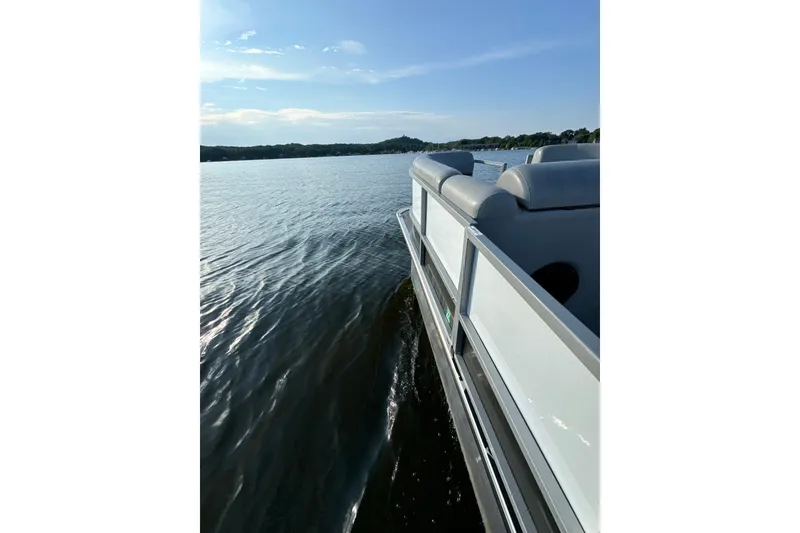 Slide: The Image of 2019 Bentley Pontoons 220/223 Cruise on serene lake waters under a clear sky. - 12