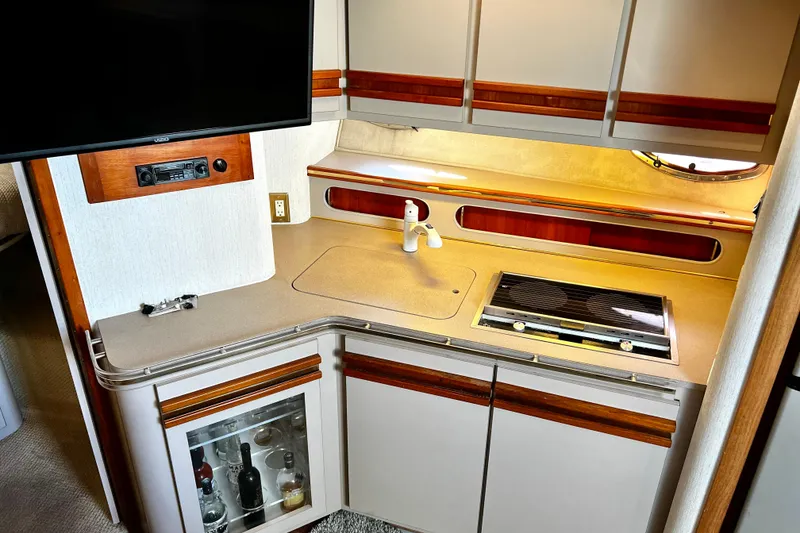 Slide: The Image of 1989 Cruisers Yachts 3670 Esprit kitchen with stove, sink, and liquor cabinet. - 16