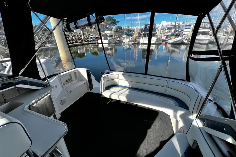 Slide: The Image of 1989 Cruisers Yachts 3670 Esprit interior with marina view, featuring seating and helm area. - 8