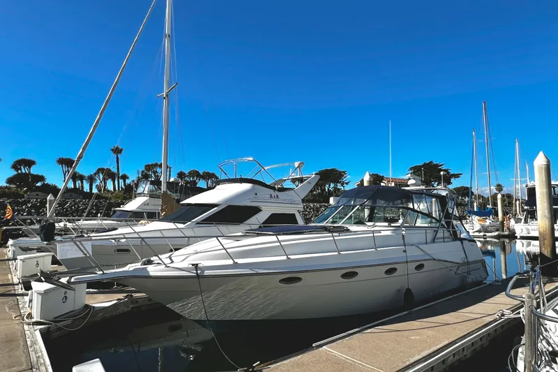 Slide: The Image of 1989 Cruisers Yachts 3670 Esprit docked at marina under clear blue sky. - 1