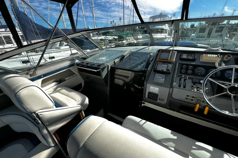 Slide: The Image of 1989 Cruisers Yachts 3670 Esprit helm with steering wheel, controls, and navigation equipment. - 10