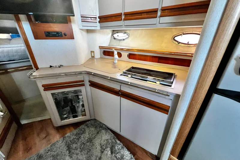 Slide: The Image of 1989 Cruisers Yachts 3670 Esprit kitchen with stove, cabinets, and porthole window. - 15