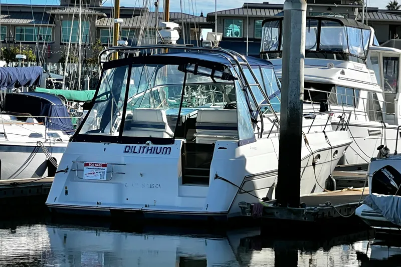 Slide: The Image of 1989 Cruisers Yachts 3670 Esprit docked at marina, labeled "Dilithium," for sale. - 2