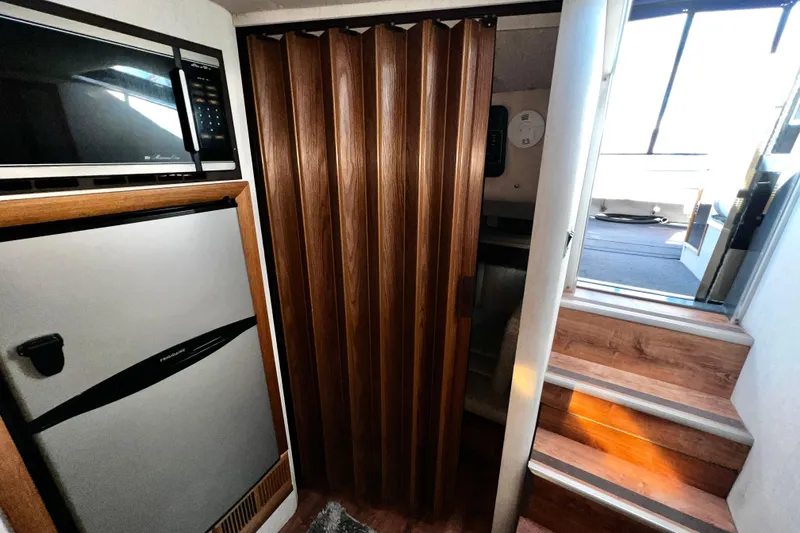 Slide: The Image of 1989 Cruisers Yachts 3670 Esprit interior with microwave, fridge, and wooden stairs. - 20