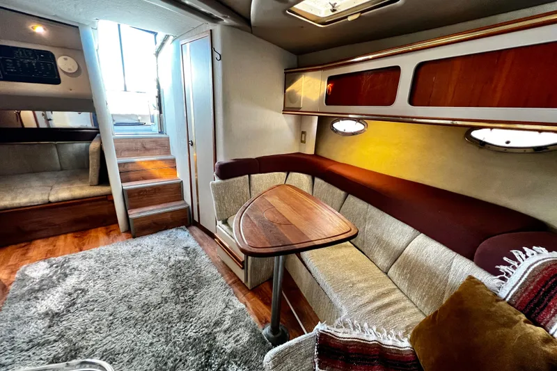 Slide: The Image of 1989 Cruisers Yachts 3670 Esprit interior with cozy seating and wooden accents. - 27
