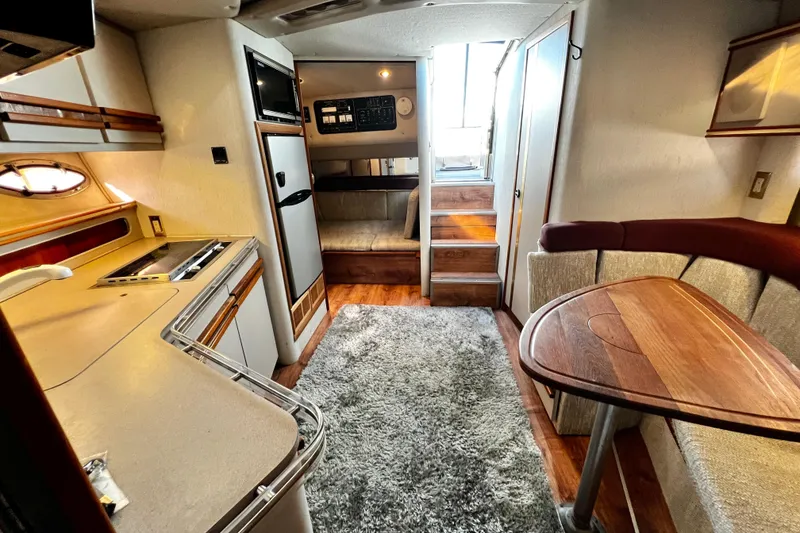 Slide: The Image of Interior of 1989 Cruisers Yachts 3670 Esprit, featuring kitchen, seating, and stairs. - 28