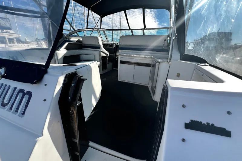 Slide: The Image of 1989 Cruisers Yachts 3670 Esprit interior with seating and helm, under blue canopy. - 4