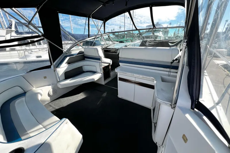 Slide: The Image of 1989 Cruisers Yachts 3670 Esprit interior with seating and helm, docked at marina. - 7