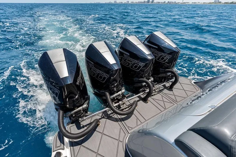 Slide: The Image of Four powerful outboard engines on a 2020 Mystic M4200 boat cruising through blue ocean waters. - 34