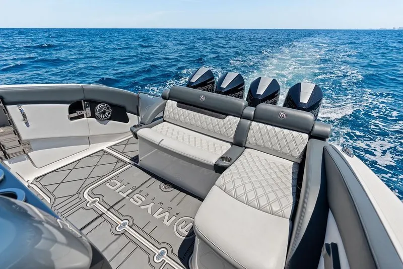 Slide: The Image of Luxury Mystic M4200 boat interior with plush seating, powerful engines, and ocean backdrop, 2020 model. - 32