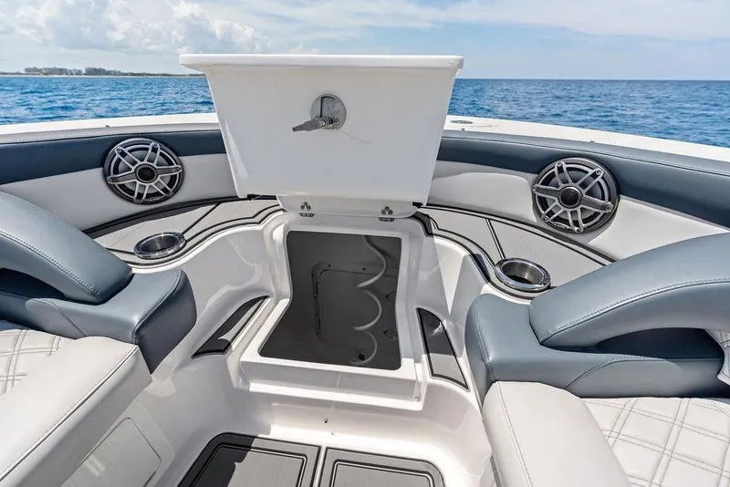Slide: The Image of Luxury Mystic M4200 boat interior with open storage, speakers, and ocean view, 2020 model. - 17
