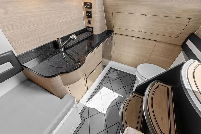 Slide: The Image of Modern yacht interior with sleek wood cabinetry, black countertop, and compact bathroom in Mystic M4200, 2020. - 40