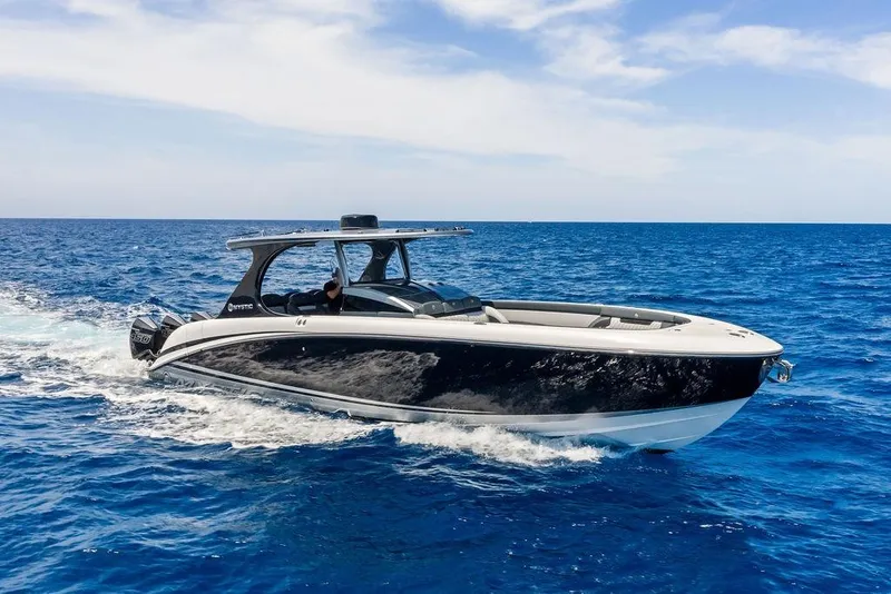 Slide: The Image of 2020 Mystic M4200 boat cruising on open blue ocean under clear sky. - 10