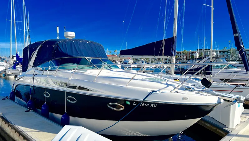 Slide: The Image of 2008 Bayliner 320 boat docked at marina under clear blue sky. - 2