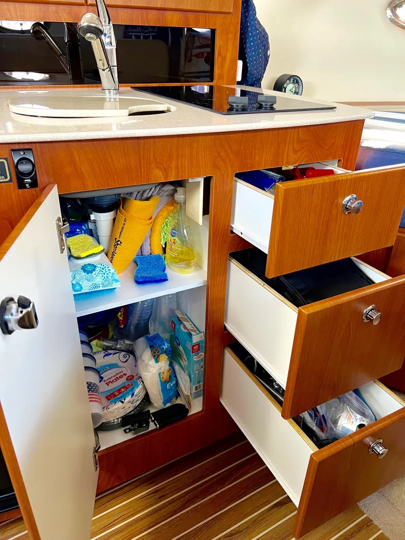 Slide: The Image of 2008 Bayliner 320 interior with wood cabinetry and compact refrigerator. - 41