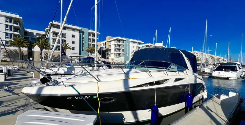 Slide: The Image of 2008 Bayliner 320 boat docked at marina, clear blue sky, waterfront building in background. - 9