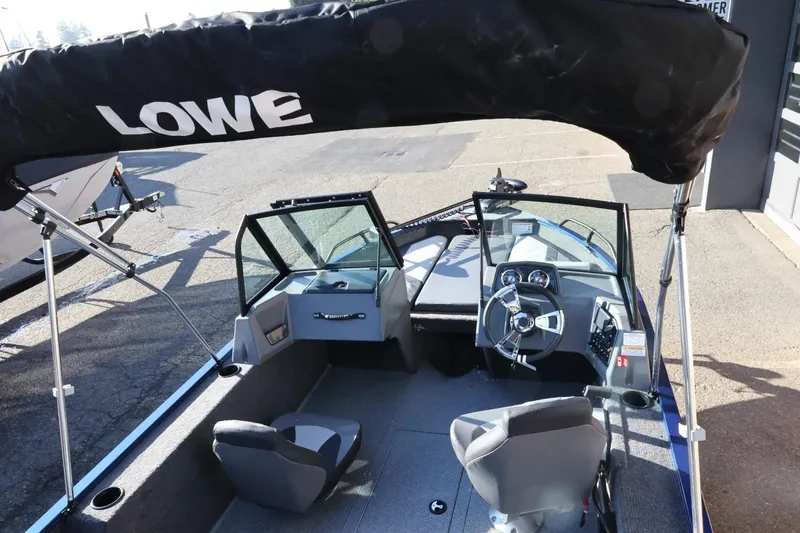 Slide: The Image of 2026 Lowe Fish & Ski 1625 boat interior with steering wheel and seating. - 16