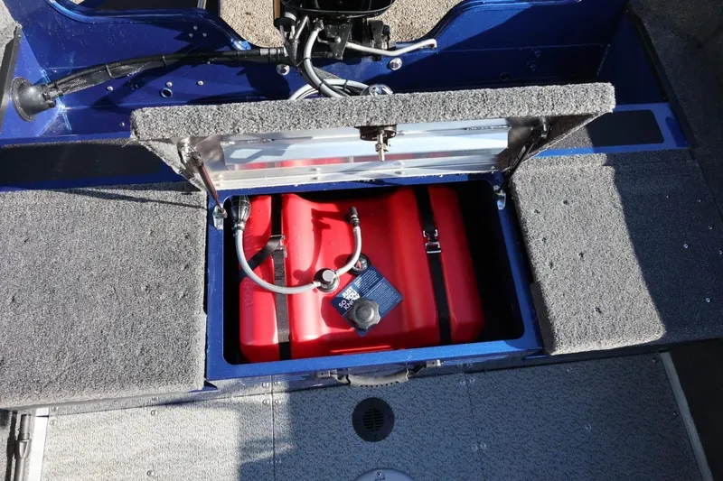 Slide: The Image of Open storage compartment in 2026 Lowe Fish & Ski 1625 boat, revealing red fuel tank. - 22