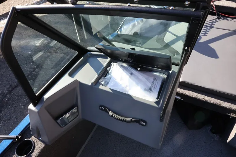 Slide: The Image of 2026 Lowe Fish & Ski 1625 boat dashboard with open storage compartment. - 30